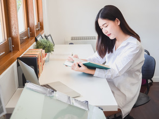 Obraz na płótnie Canvas asian woman reading book in working room