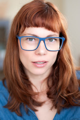 Obraz premium Porträt einer coolen rothaarigen Frau mit Brille
