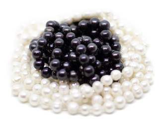 Two strands of white and black pearls on white background isolated