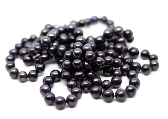 Natural cultered black pearl beads string on a white background isolated