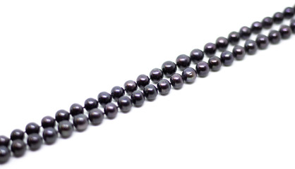 Natural cultered black pearl beads string on a white background isolated