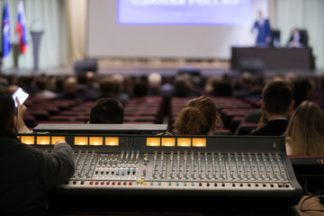 Audio engineer operating mixing console with hands