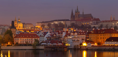 Prague - The Mala Strana, Castle and Cathedral from promenade over the  Vltava river at dusk.