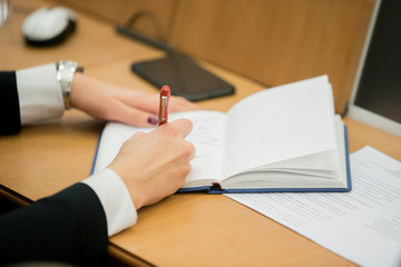 Business concept: Businessman writing on blank notebook. Holding pen in right hand.