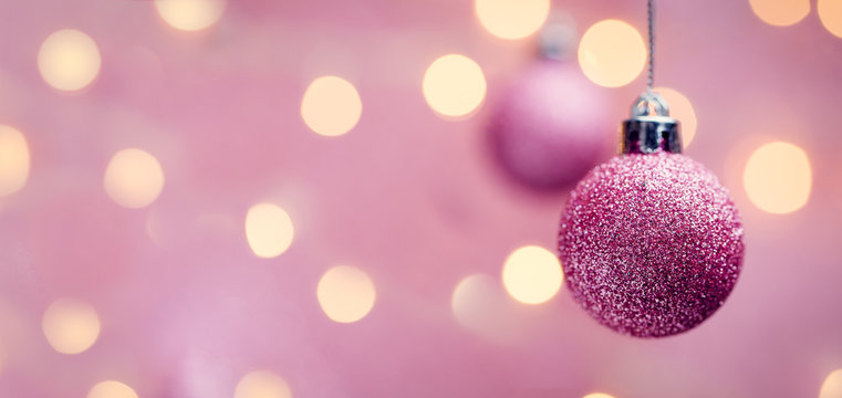 Picture of two New Year's pink balls on pink background with spots.
