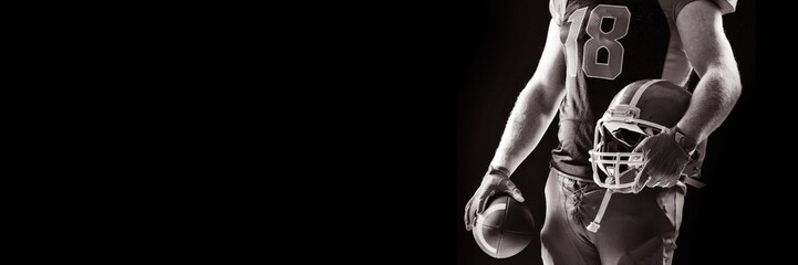 American football player standing with helmet and rugby ball