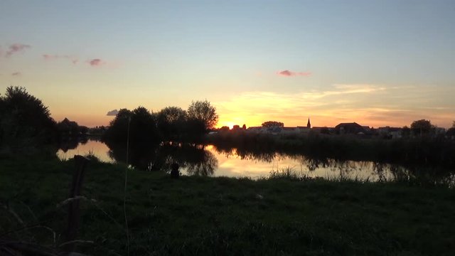 Sun Setting on Lake with Dutch Landscape and Church in background