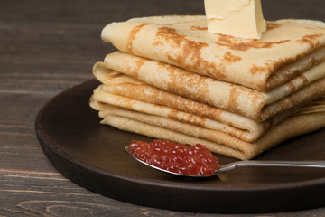 Closeup of pancakes with spoon with red caviar and butter