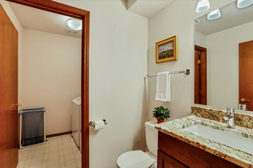 Small guest Bathroom with wood vanity and open door