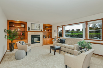 Classic traditional white living room with wood shelves and large windows