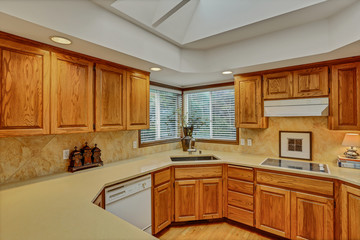 Open large kitchen interior with vaulted ceiling and white appliances.