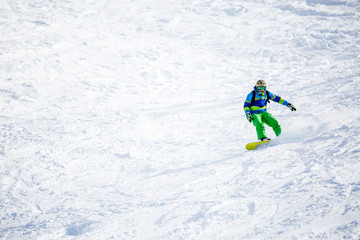 Fototapeta na wymiar Photo of sports man snowboarding on snowy slope