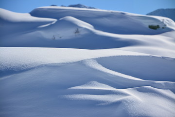 Fototapeta na wymiar Snowy surface with blue sky and mountains