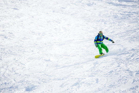 Photo of sports man snowboarding on snowy slope
