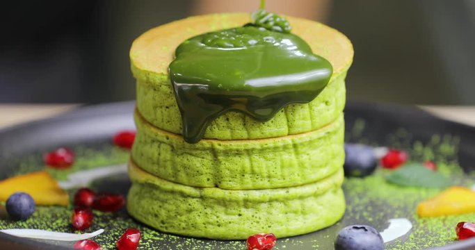 Pouring green macha syrup on the healthy delicious cake