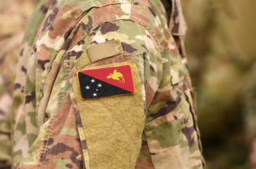 Fototapeta premium Papua New Guinea flag on soldiers arm. Papua New Guinea troops (collage)