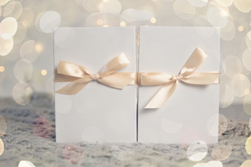 Two Christmas Gift in White Box with light Ribbon on Light Background. New Year Holiday Composition Banner. Copy Space For Your Text