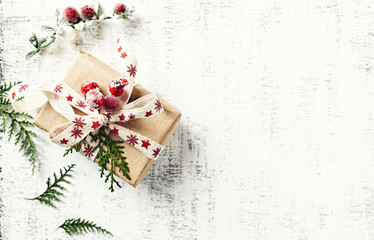 Christmas present wrapped in brown paper on white wooden background. Flatlay. Copy space