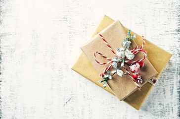 Christmas presents wrapped in brown paper on white wooden background. Flatlay. Copy space