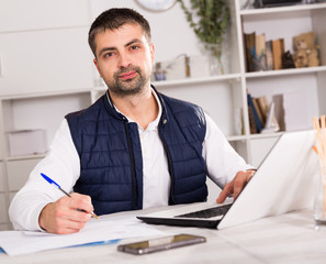 Portrait of male business working in office with laptop
