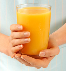 WOMAN HOLDING GLASS OF ORANGE JUICE