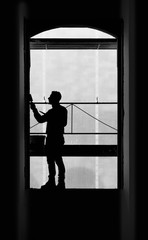 Worker balancing on a window while working