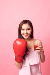 Young Asian woman with tomato juice and boxing glove.