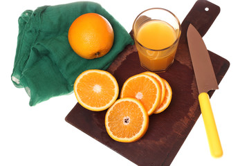 Culinary concept. Juicy fresh oranges on a cutting wooden board, green napkin and a glass of orange juice.