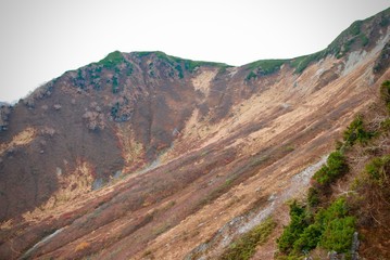 Highland in autumn time with mountain range and grass field above the cloud level in sunshine day 