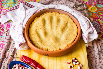 Mchadi made in ketsi clay dish - traditional Georgian corn bread with woman hand printed trace on surface.