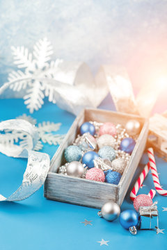 Pink and blue Christmas balls and wrapping paper for gifts with old photo frame on wooden table