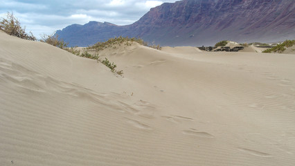 Sandverwehungen am Strand von Famara auf Lanzarote