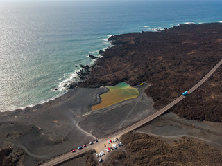 Vista aerea del piccolo lago sotto la montagna Bermeja, vista della spiaggia nera e della strada...