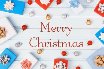 In the center of the blue background is the inscription Merry Christmas. In a circle are red, gold and silver Christmas balls, gift boxes with bows.
