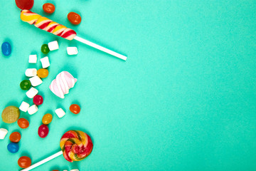 Colorful candies on pastel turquoise background. Flat lay