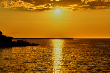 Fototapeta na wymiar Sunset over the sea in the bay of Sevastopol. The sun sets in the sea..The golden reflection of sunlight on the sea surface. Calm sea without excitement. nature concept for design.