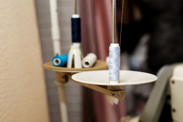 round plates of sewing machine with spools of threadsloaded into machine. Tailor industry concept