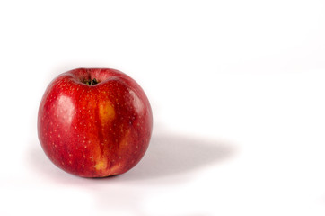 Healthy food. A red appetizing apple with a yellow side lies on a white isolated background