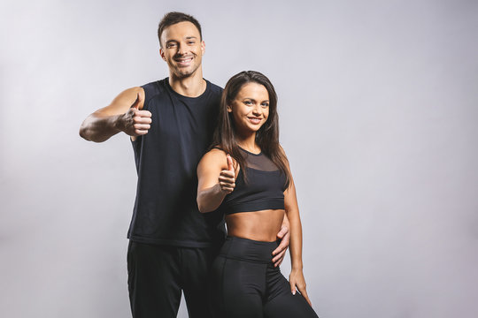 Athletic man and woman isolated over white background. Personal fitness instructor. Personal training. Thumbs up.