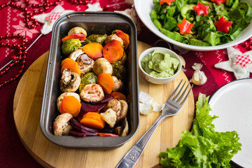 Hot baked, roasted, grilled vegetables in metal baking form. Beetroot, carrot, mushrooms, pumpkin, brussels sprouts with avocado dip sauce. Vegan red Christmas lunch, vegetarian dinner, healthy food