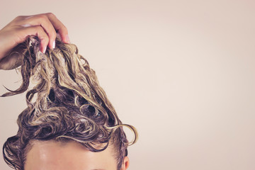 Funny woman pulls himself wet hair up. Close-up, space for text. Hair care concept