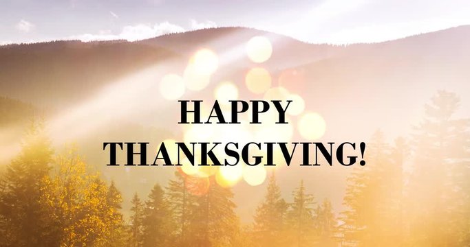 Happy Thanksgiving - holiday message on mountain landscape backdrop with dramatic rays and flickering lights. Dramatic lens flare effect to emplasize the message.