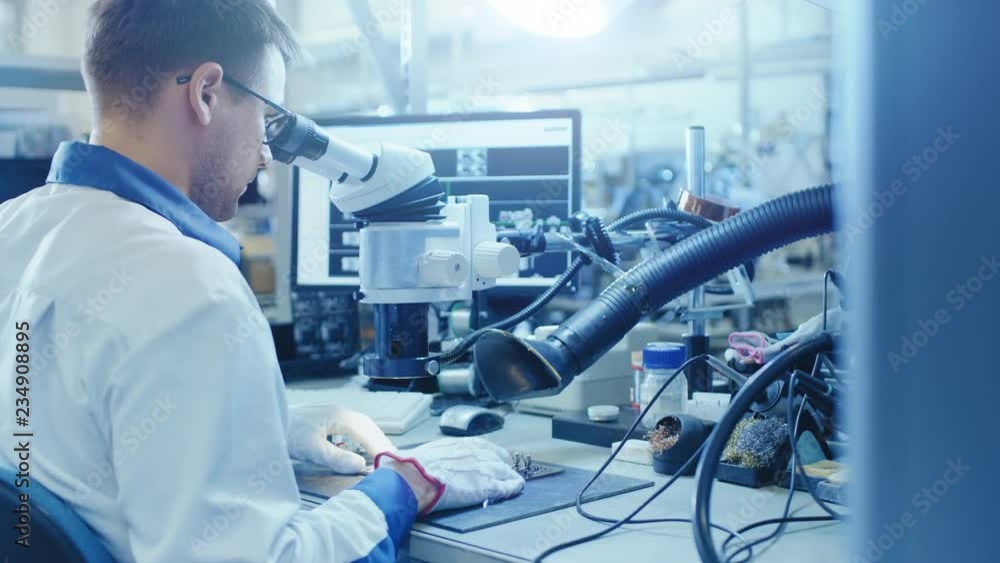 Aufkleber electronics factory worker in white work coat inspects a printed circuit board through a digital mic