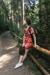 girl traveler in forest near a mountain lake