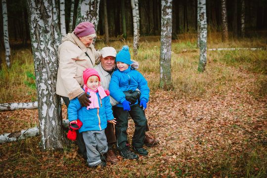 active senior grandparents with kids walk in nature