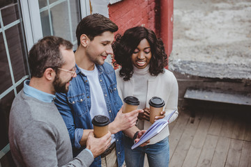 multiethnic colleagues talking about work and having coffee