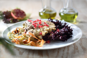 Pieczony kalafior z sosem jogurtowym podany z owocem granatu. © foodandcook