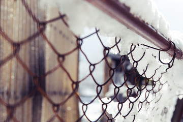 Snow on a rusty fence