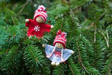Cute christmas gnomes on fir tree branch, outdoors