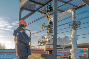 The operator services an oil well in the northern oil field in winter. The equipment for oil...